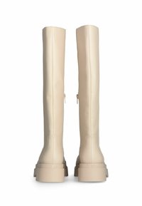 Stivali beige al ginocchio in materiale sintetico liscio, con suola spessa, branding discreto e zip laterale per maggiore comodità.