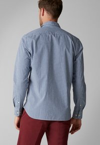 Koszula zapinana na guziki w niebiesko-białą kratę, wykonana z tkanego bawełny, z długimi rękawami i standardowymi mankietami.