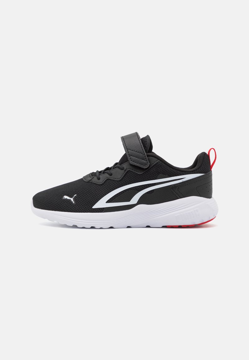 Scarpe da ginnastica nere con upper in mesh, striscia di accento bianca, cinturino regolabile e suola bianca con dettagli rossi.