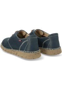 Zapatos de cuero azul marino con un diseño de caña baja, suela beige moteada, detalles de costura visibles y cierre con cordones.