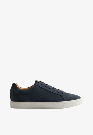 Marineblauwe suède lage sneaker met witte rubberen zool en bijpassende marineblauwe veters, zijaanzicht op een witte achtergrond.
