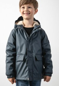 Wodoodporna granatowa kurtka z kapturem z futerkiem, przednimi kieszeniami i elastycznymi mankietami; zawiera guziki i zamki błyskawiczne.