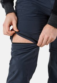 Men's navy blue zip-off pants with a smooth, lightweight texture, featuring a zip closure on the thigh for easy removal.