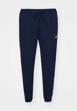 Pantalones de chándal en azul marino hechos de una tela suave, con cintura elástica y cordón ajustable. Presenta perneras ajustadas y un sutil acento de logo cerca de la cadera.