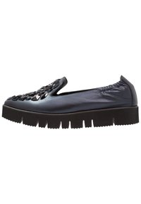 Černá nazouvací bota s lesklým povrchem, která má dekorativní, faceted design na přední části a silnou, vroubkovanou černou podrážku.