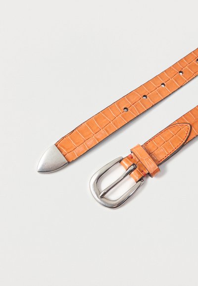 Φωτεινό καφέ δερμάτινη υφασμάτινη ζώνη με ασημί μεταλλική αγκράφα και άκρη, τοποθετημένη επίπεδη πάνω σε λευκή επιφάνεια.