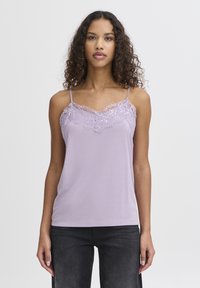Helllila Spaghetti-Top mit Spitzenbesatz entlang des Halsausschnitts. Verfügt über dünne, verstellbare Träger und eine glatte Stoffqualität. Klassischer Schnitt.