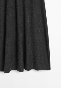 Donkergrijze wollen rok met een gladde textuur, met een uitlopende stijl en een zoom die zachtjes naar boven gebogen is.