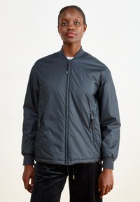 Giubbotto bomber grigio scuro con una texture liscia e opaca, chiusura frontale con zip e tasche laterali. Dotato di polsini a coste e colletto alto.