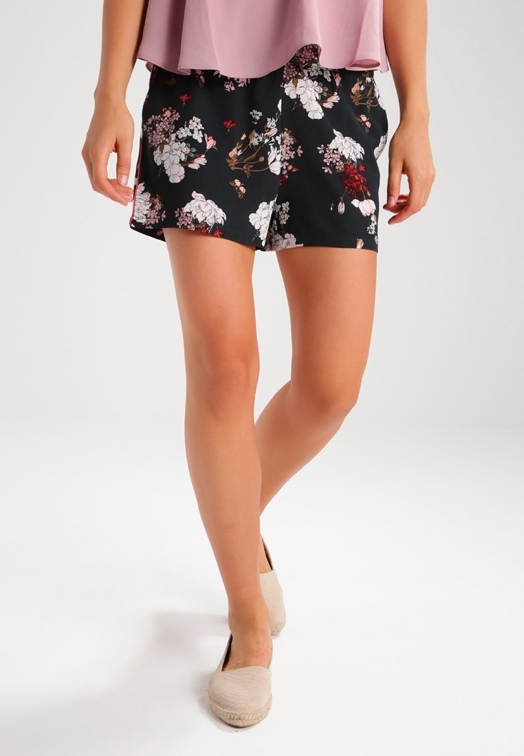 Shorts noirs à motifs floraux variés en rose et blanc, confectionnés dans un tissu léger avec une coupe ample et un design décontracté.