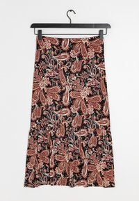 Musta hamje, jossa on ruskeita ja beigejä paisley-kukkakuvioita, riippuu mustalta henkarilta valkoista taustaa vasten.