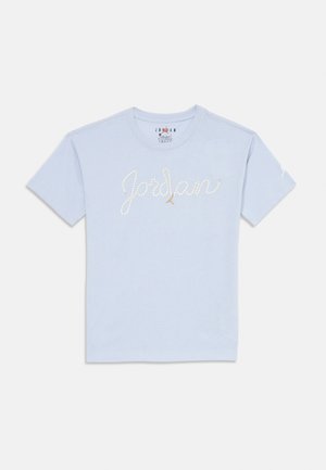 T-shirt in cotone azzurro chiaro con la scritta in corsivo "Jordan" in strass bianchi e un piccolo logo dorato Jumpman sul petto. Maniche corte.