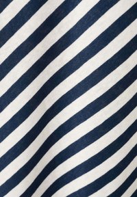 Gros plan d'un tissu avec des rayures diagonales bleu marine et blanches montrant la texture et de légers plis.