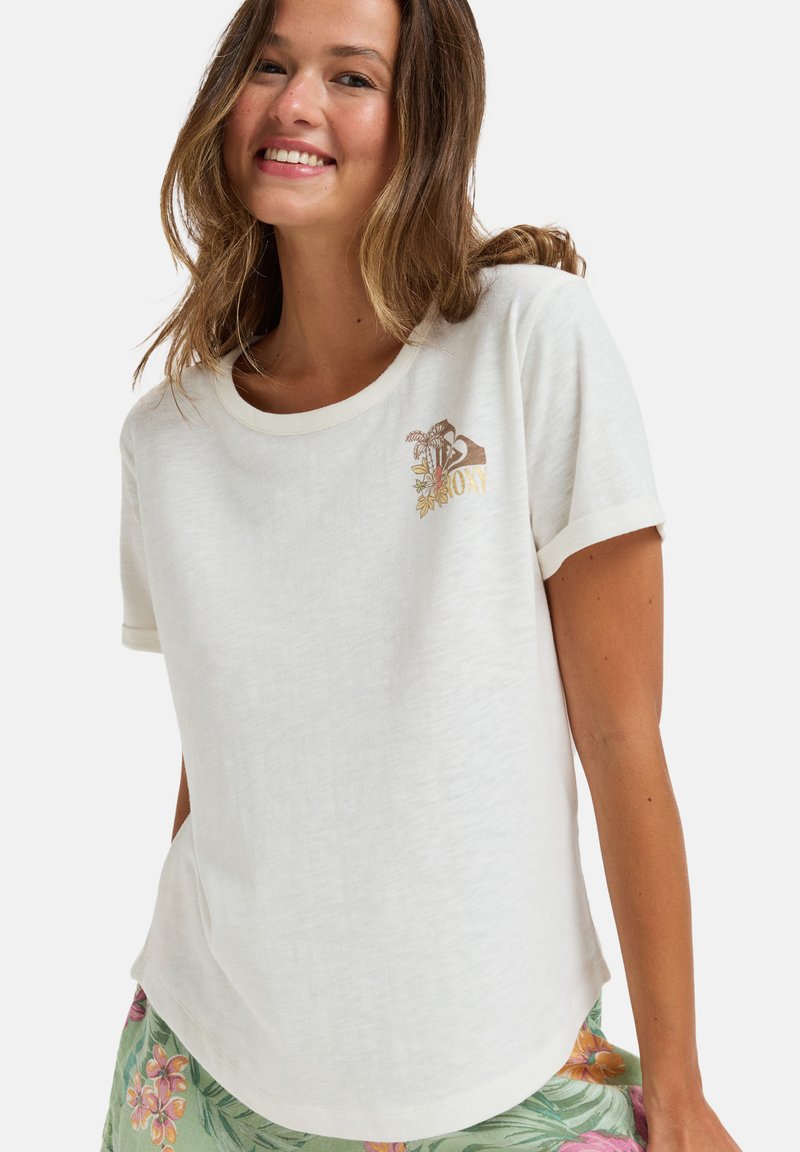 Camiseta blanca de manga corta con un cuello redondeado y una textura ligera. Presenta un diseño floral bordado en tonos dorados y marrones.