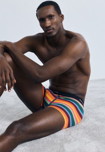 Herren-Boxershorts mit einem lebhaften Regenbogen-Streifenmuster. Hergestellt aus einem weichen Stoff, mit einem schwarzen Bund und Logo.
