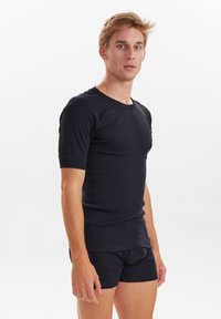 Sort kortærmet T-shirt og matchende boxer shorts, lavet af glat stof, med en klassisk rund halsudskæring og tætsiddende pasform.