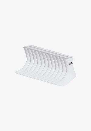 Calcetines cortos blancos dispuestos en una fila, con parte superior acanalada y el logo de Adidas en negro. Fabricados en material suave y transpirable.