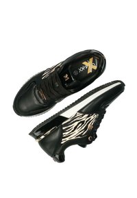 Svarta sneakers med en texturerad läderöversida med zebramönstrade detaljer, kontrasterande vit mellansula och detaljer i guldton.