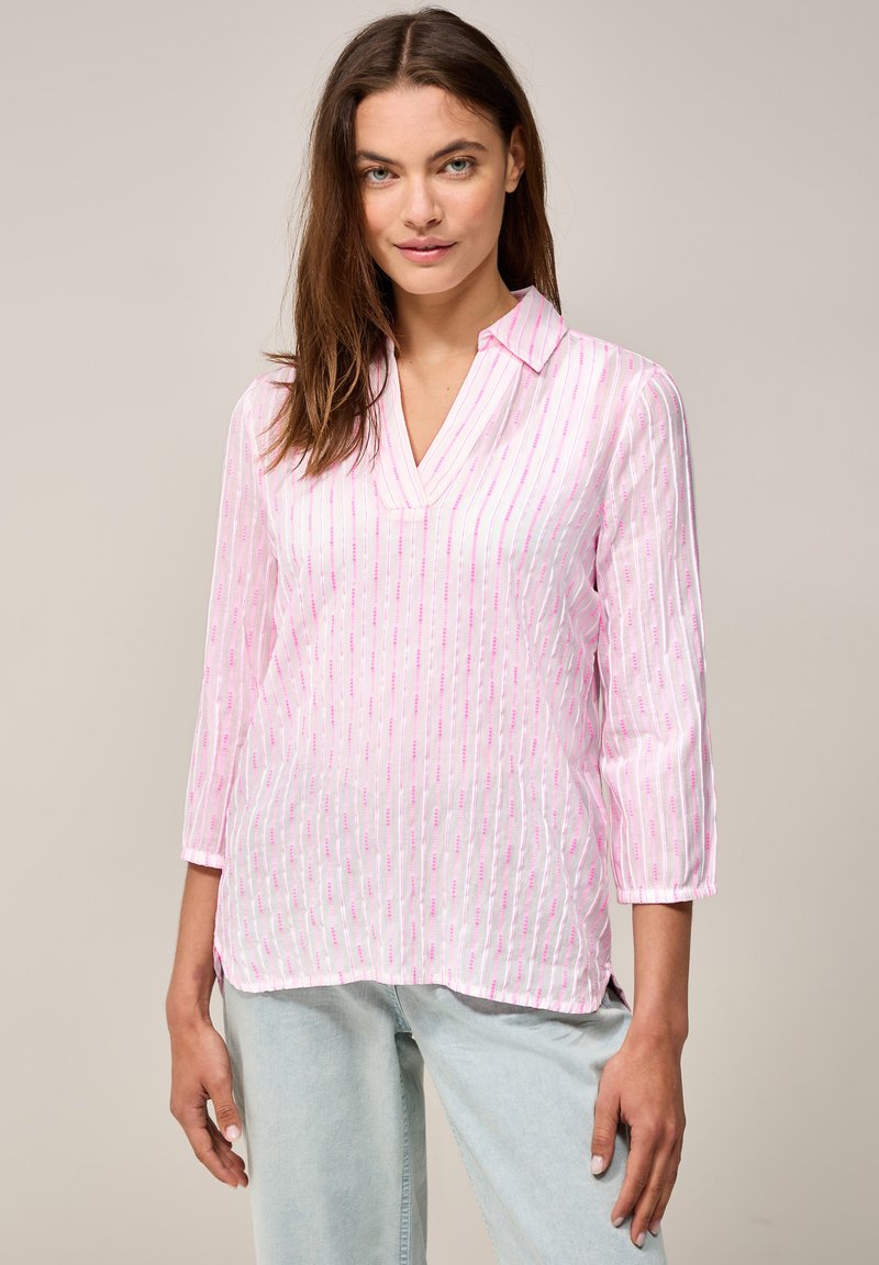 Blouse rose clair avec un col, dotée de rayures verticales en rose foncé et blanc. Le tissu semble léger avec une texture subtile.