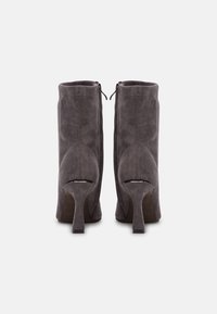 Szare zamszowe botki na wysokim obcasie, o gładkiej fakturze i bocznych suwakach ułatwiających zakładanie. Klasyczna sylwetka o wyrafinowanym designie.