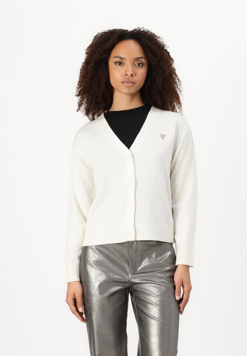 Cardigan blanc en tricot avec un col en V et une fermeture à boutons, arborant un petit logo sur la poitrine gauche et des poignets côtelés.