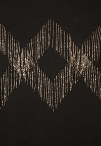 Černá tkanina s diamantovým vzorem, zdobená metalickými třásněmi, vytvářejícími vertikální linie různé délky a lesku.