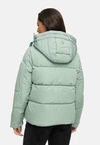 Mint green puffer jacket with a hood, featuring diagonal stitching and a logo detail on the back, paired with black pants.