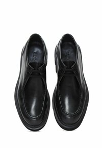 Zwarte leren schoenen met een gladde afwerking, ronde neus en subtiele vetersluiting. Ontworpen met een lage profiel en minimale stikselaccenten.