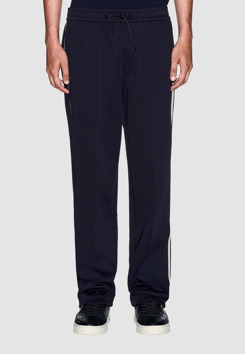 Marineblauwe sweatpants met een relaxte pasvorm, elastische tailleband, trekkoord en zijdetails in een contrasterende kleur. Zachte, ademende stof.