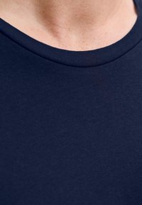 T-shirt in cotone blu navy con colletto rotondo a costine, che mostra una texture liscia e una vista ravvicinata della zona del collo.