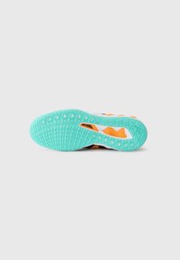 Black and white athletic shoe sole with a textured mint green outsole and orange accents, featuring circular grip patterns and a pull tab.