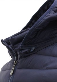Giacca puffer blu navy con colletto alto, zip anteriore e texture trapuntata. Presenta una tasca con zip all'interno.
