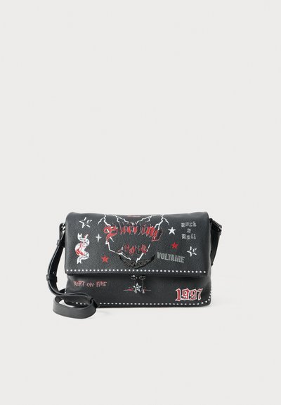 Geantă crossbody din piele ecologică neagră, cu decorațiuni grafice roșii și albe, inclusiv text, stele și o curea decorativă. Formă compactă, rectangulară.