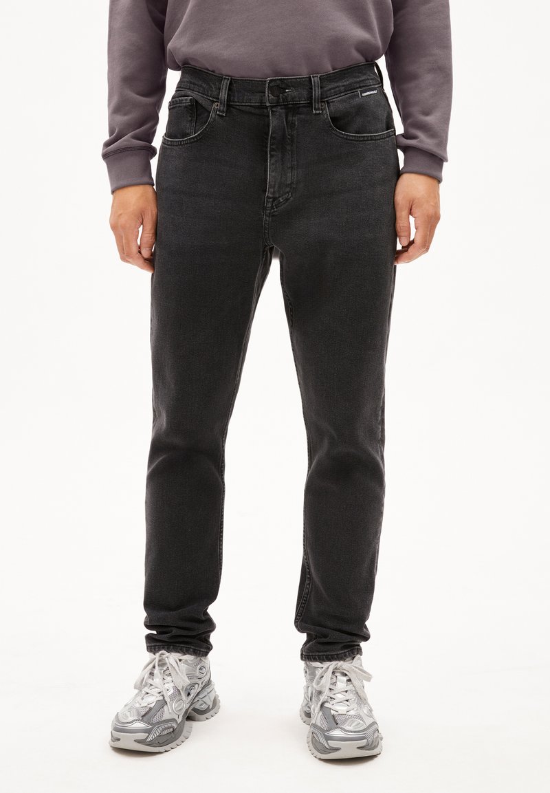 Schwarze Jeans aus Denim mit geradem Schnitt, ausgestattet mit zwei Fronttaschen, einem kleinen Markenetikett und einem klassischen Fünf-Taschen-Design.