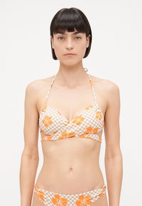 Bikini komplet z karirastim bež in oranžnim cvetličnim vzorcem. Zgornji del ima triangel obliko z vezmi za vrat, spodnji del pa je poudarjen s stranskimi naborki.