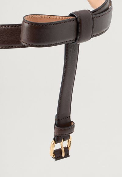 Smeđi kožni remen s glatkom teksturom, koji ima kopču u zlatnoj boji i detalje šivanja; dizajniran za prilagodljivost i elegantan izgled.