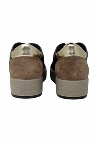 Sneakers in suede marrone e materiale nero con un accento metallizzato oro e un tacco a zeppa, dotati di una suola testurizzata per una maggiore aderenza.