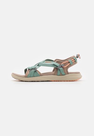 Open-toe outdoor sandal with beige sole, green and peach adjustable straps, and cushioned ankle support designed for hiking or casual wear.
