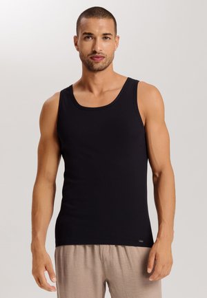 Sort bomulds tanktop med en klassisk rund halsudskæring, tætsiddende form og uden ærmer. Glat tekstur, partnerskab med lyse bukser.
