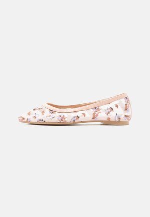 Beige ballerina met bloemenpatroon, spits toelopende neus en lage hak op een effen grijze achtergrond.
