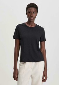 Zwarte t-shirt met korte mouwen en een ronde hals, gemaakt van glad katoen, met een relaxte pasvorm en een minimaal ontwerp.