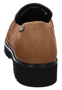 Chaussure slip-on en cuir suédé marron avec une semelle en caoutchouc noir. Dotée d'un talon bas et d'une finition cousue le long du bord. Détail du logo en or sur le côté.