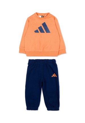 Ensemble de sport deux pièces pour enfants avec un haut orange à manches longues arborant un logo bleu marine et un pantalon bleu marine à taille élastique avec petit logo assorti.