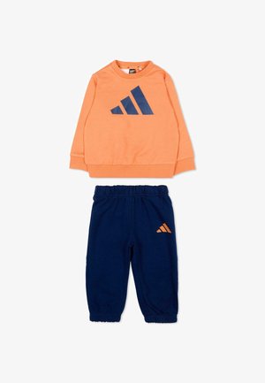 Ensemble de sport deux pièces pour enfants avec un haut orange à manches longues arborant un logo bleu marine et un pantalon bleu marine à taille élastique avec petit logo assorti.