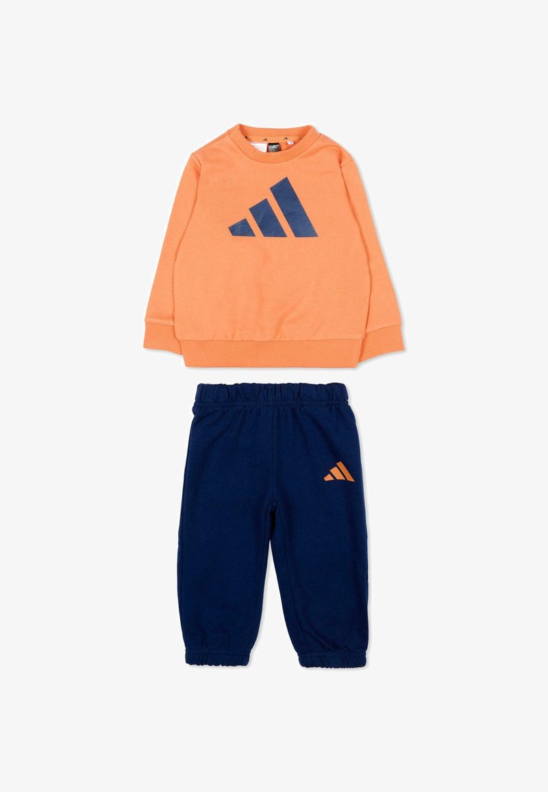 Ensemble de sport deux pièces pour enfants avec un haut orange à manches longues arborant un logo bleu marine et un pantalon bleu marine à taille élastique avec petit logo assorti.