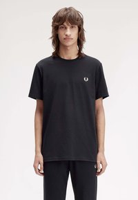 Zwarte katoenen T-shirt met korte mouwen, ronde halslijn, met een klein wit geborduurd logo op de linkerkant van de borst. Eenvoudige, gestructureerde stof.