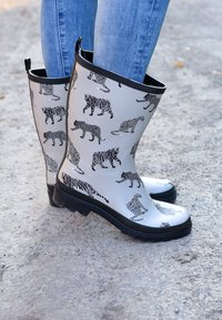 Bottes de pluie en caoutchouc gris avec imprimés animaux noirs, présentant divers motifs de félins sauvages. Semelle et bordure noirs. Hauteur mi-mollet. Surface texturée.