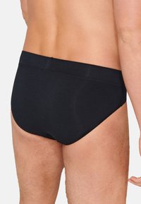 Doppi e neri in cotone con una texture liscia e una vita elastica, caratterizzati da una vestibilità aderente e da un design minimalista. Senza motivi visibili o accessori.
