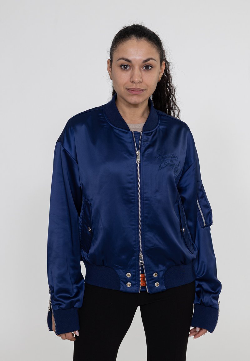 Marineblaue Satin-Bomberjacke mit Reißverschluss vorne, gerippten Bündchen und Seitentaschen; verfügt über ein gesticktes Logo und eine glänzende Textur.