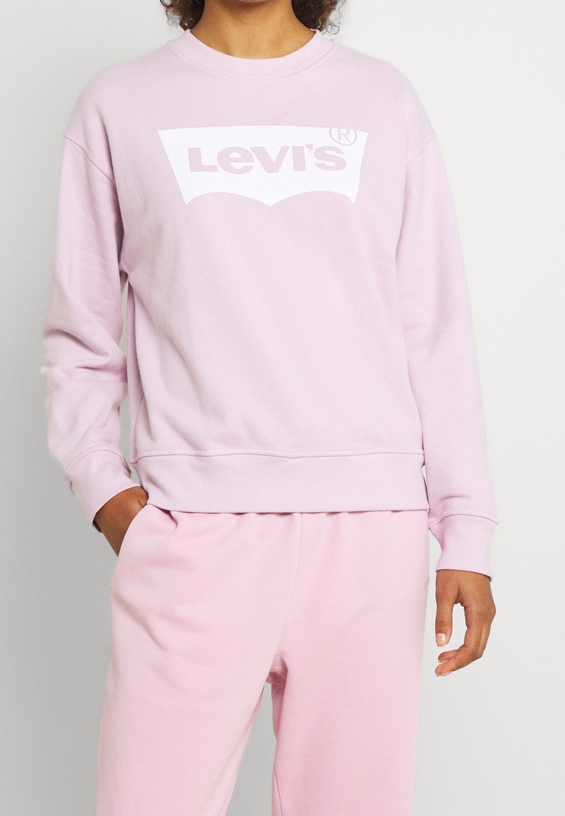 Sweat-shirt rose avec un logo Levi's blanc. Encolure ronde, manches longues, coupe décontractée et poignets côtelés. Tissu doux en mélange de coton.